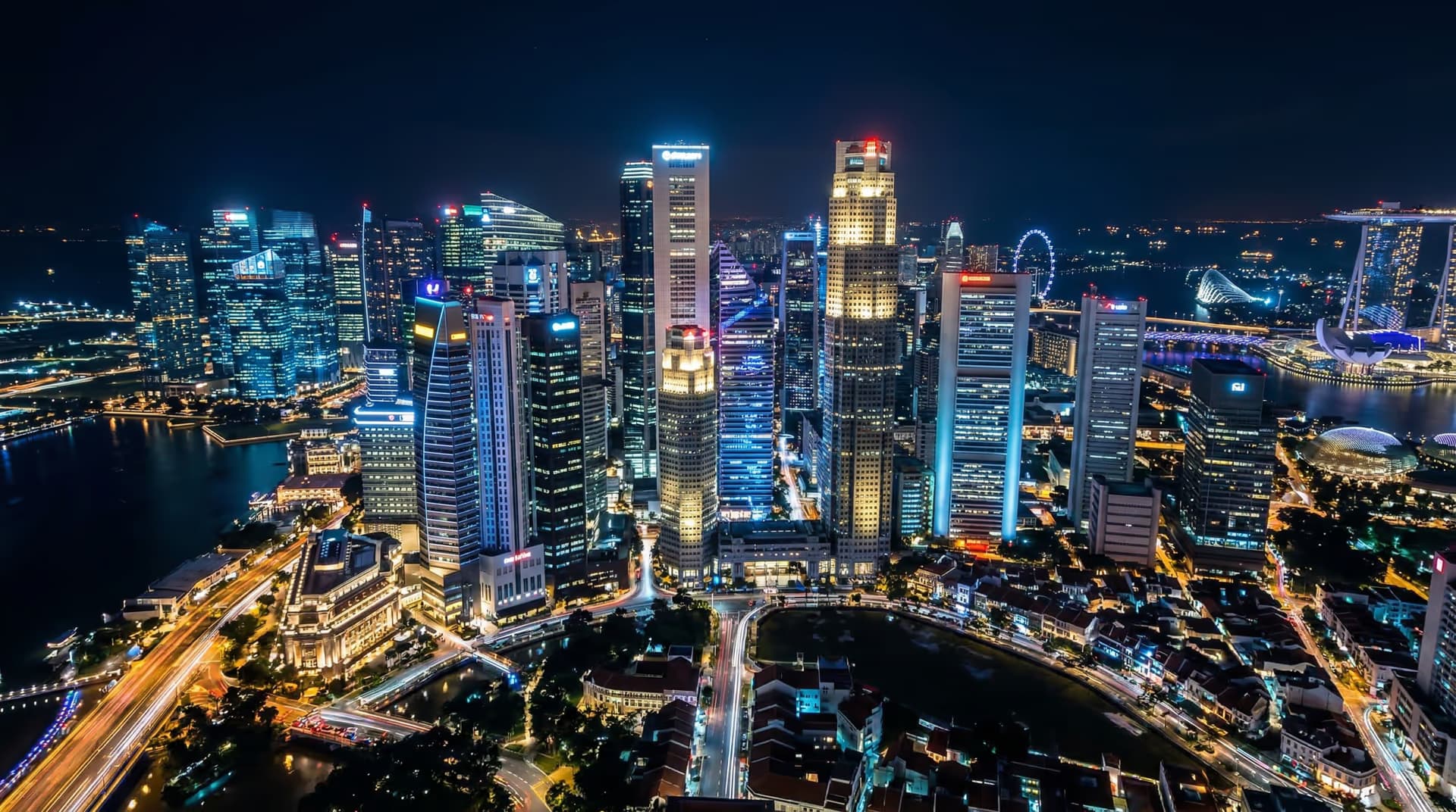 Aerial night view of Singapore central business district — conveying the scale of institutional capital and global financial infrastructure