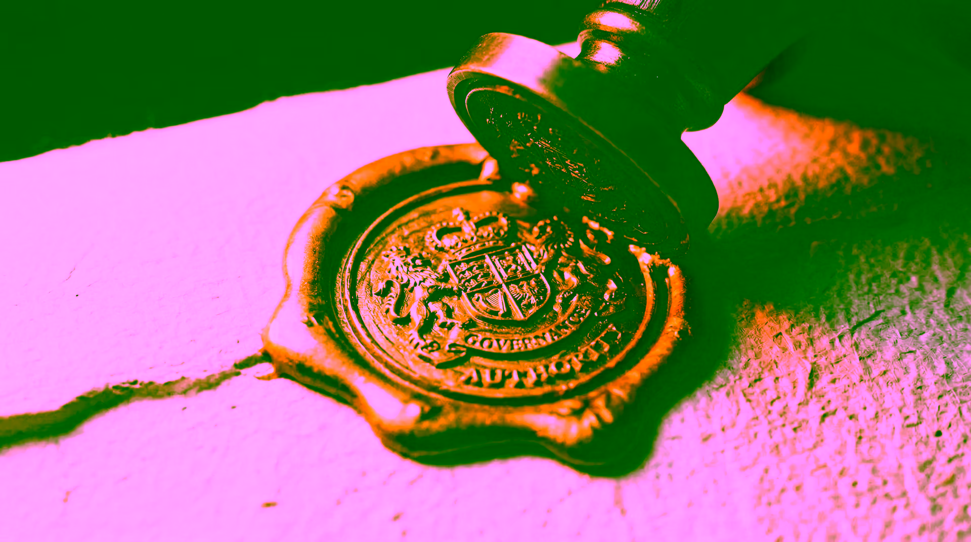 Macro close-up of a gold wax seal being pressed onto paper, representing GDV Holdings' formal governance authority and institutional commitment